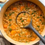 white bean stew in dutch oven topped with fresh parsley