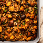 vegan mushroom stuffing in baking dish topped with parsley