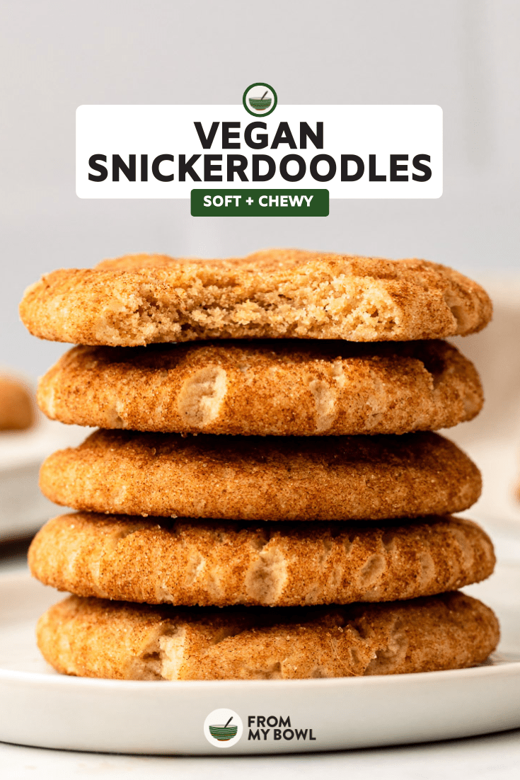 a stack of vegan snickerdoodles with a single bite taken off the one on the top