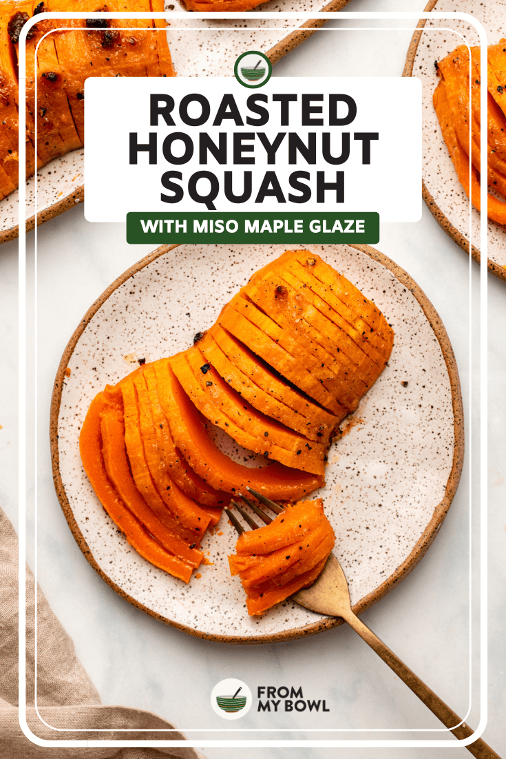 Fork slicing through roasted honeynut squash on small white plate