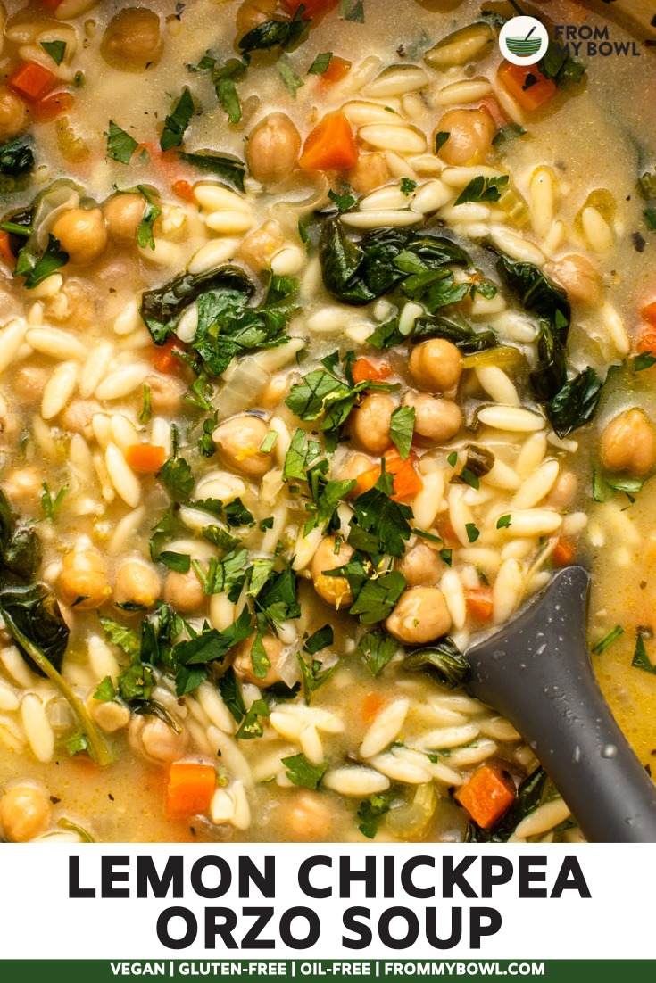 Large pot of lemon chickpea orzo soup with soup spoon mixing the soup