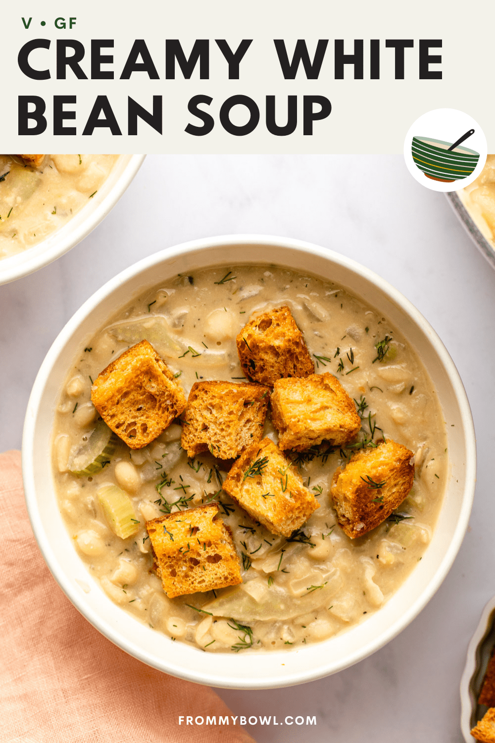 creamy white bean soup served in a white bowl and topped with croutons, 