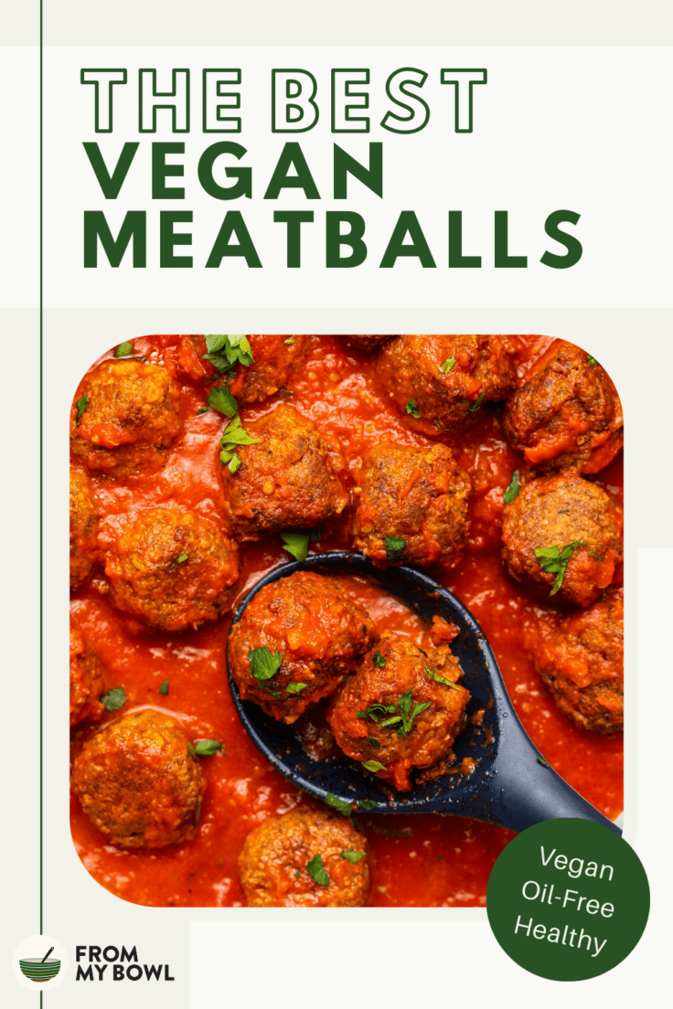 plant based meatballs served in a tomato sauce in a pan with a spoon scooping up two meatballs