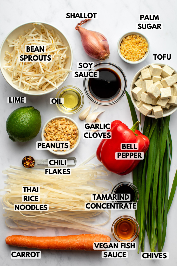 ingredients for egan pad thai served in bowls on a marble kitchen countertop