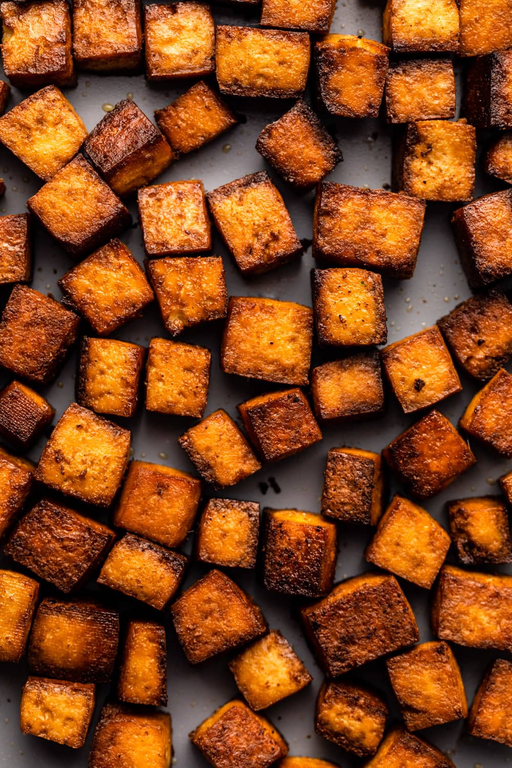 a zoomed in image of smoky marinated tofu on a baking tray