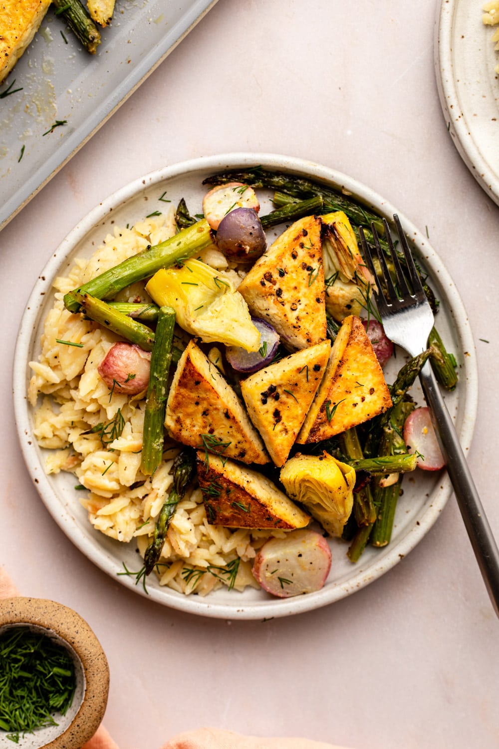 sheet pan tofu with spring vegetables served on top of lemon pepper orzo