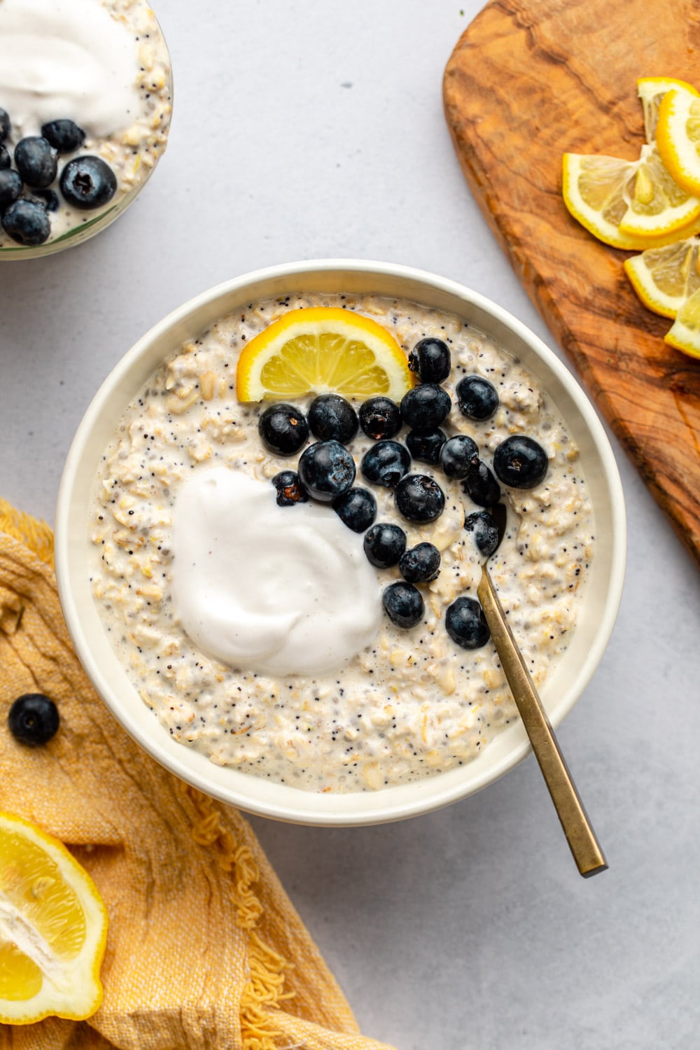 lemon poppyseed overnight oats served in a white bowl topped with berries and yoghurt