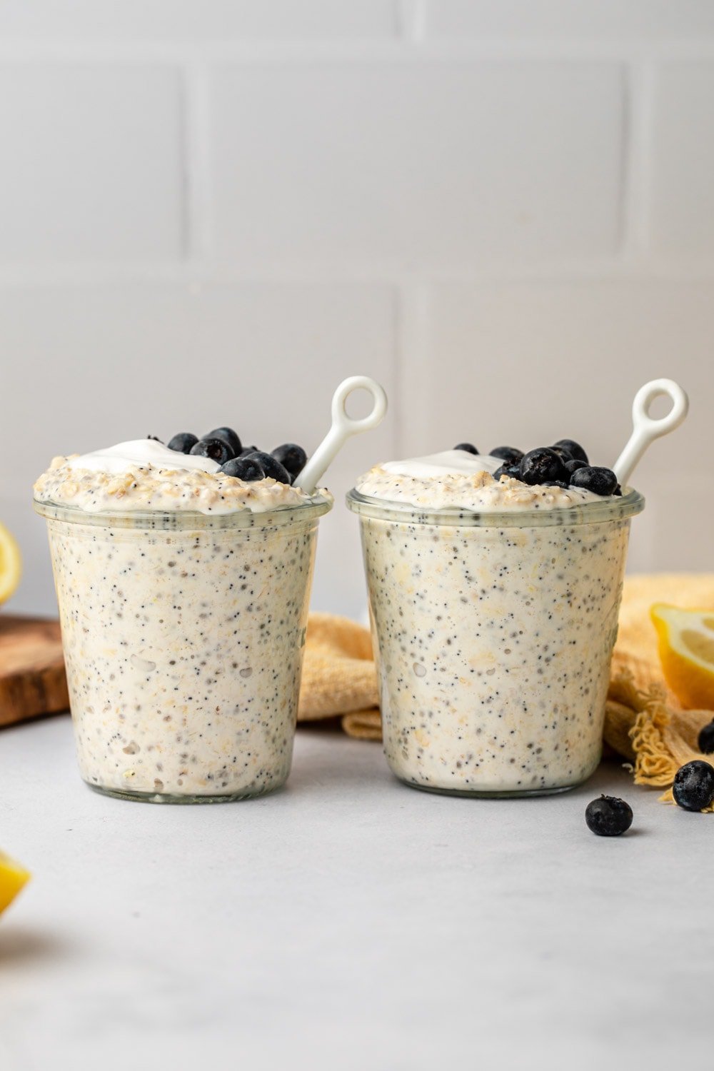 overnight oats served in two cups topped with blueberries and yoghurt