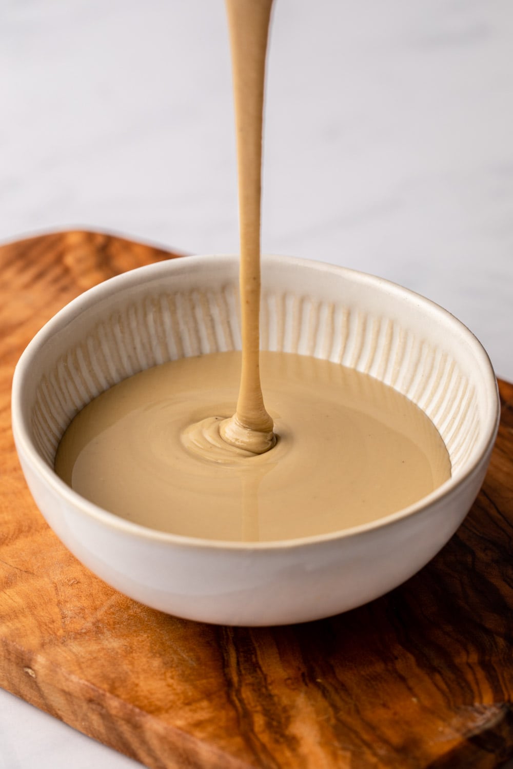 tahini dressing poured in a white cup