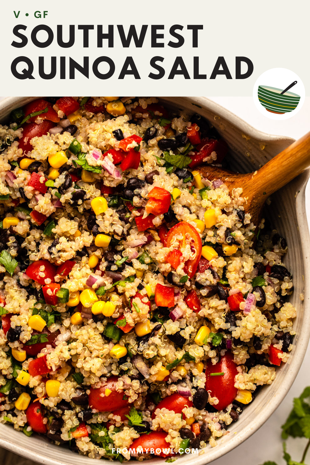 southwest quinoa salad served in a large bowl with a wooden spoon stirring