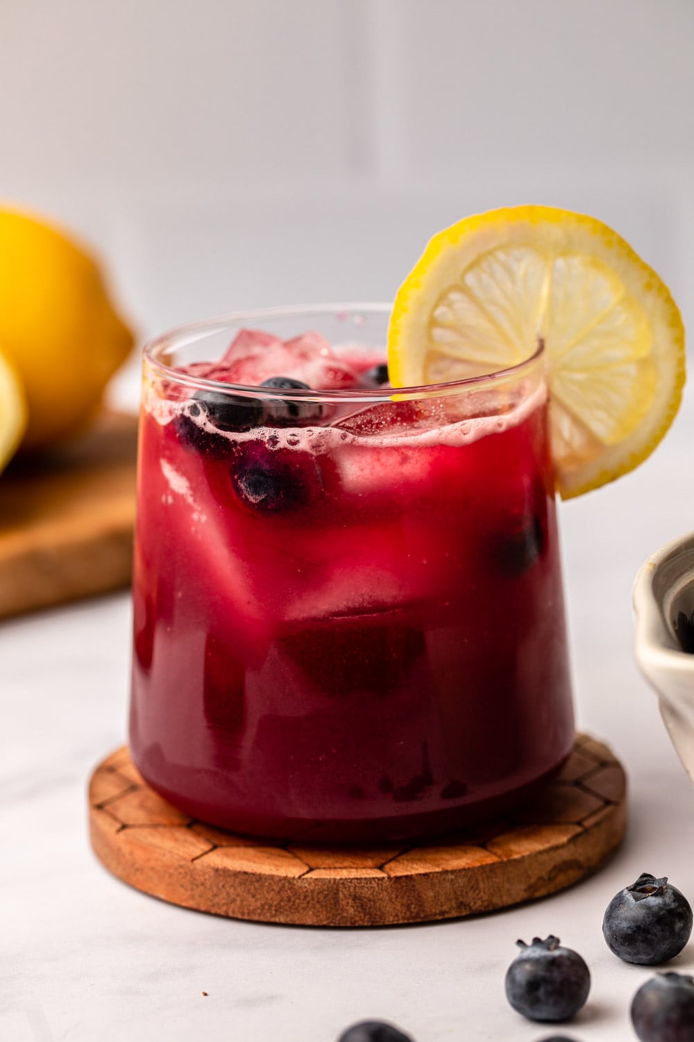 blueberry lemonade served in a glass with a slice of lemon as decoration