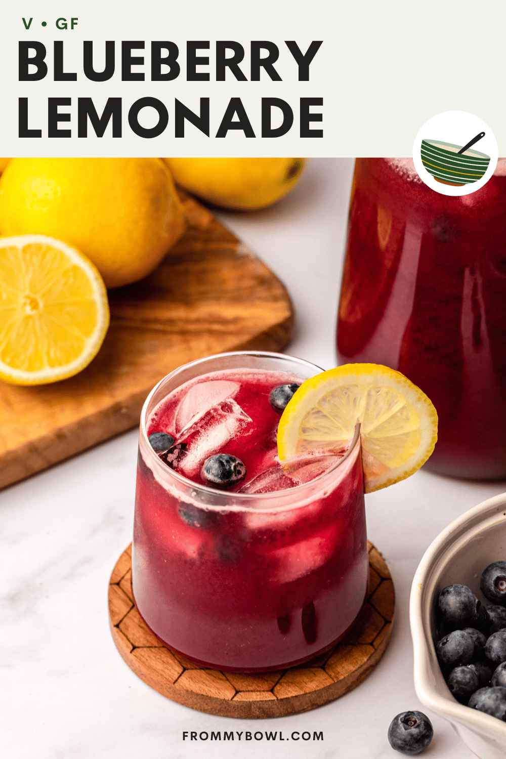 a glass of blueberry lemonade topped with a slice of lemon and blueberries
