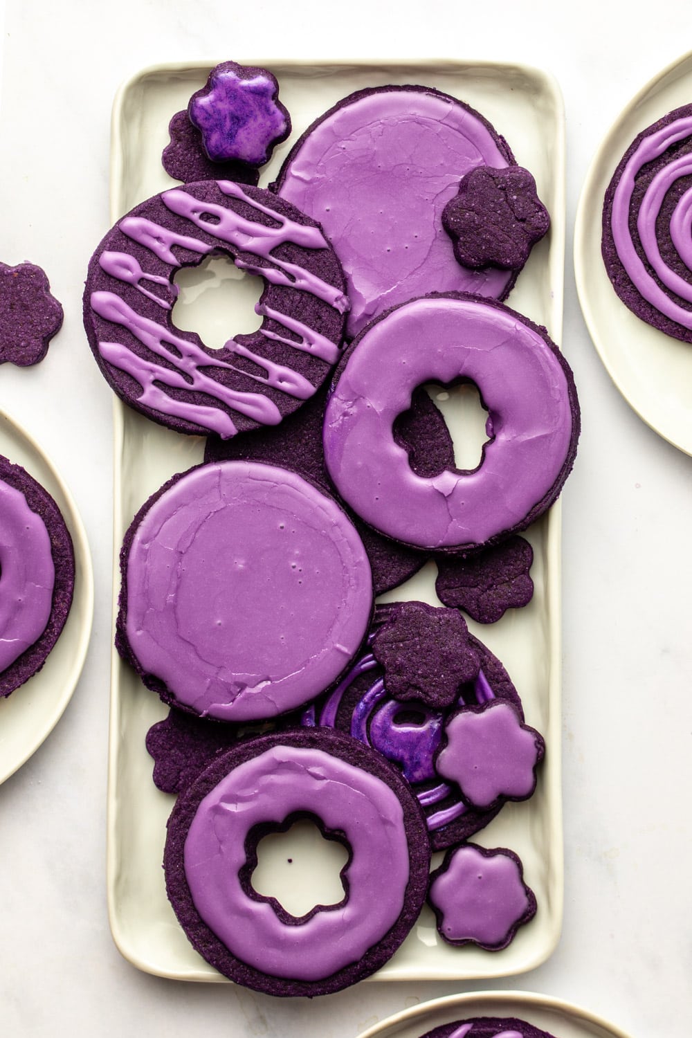 glazed ube sugar cookies served on a white rectangular plate