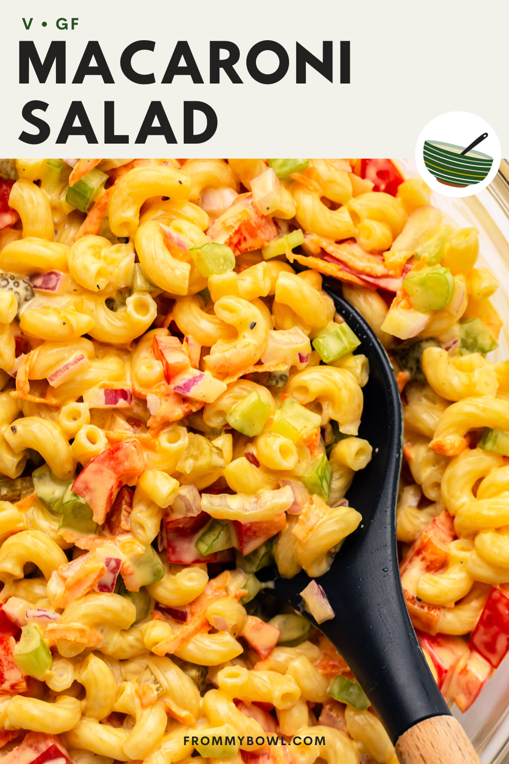 a zoomed in image of macaroni pasta salad with a plastic spoon scooping up a portion