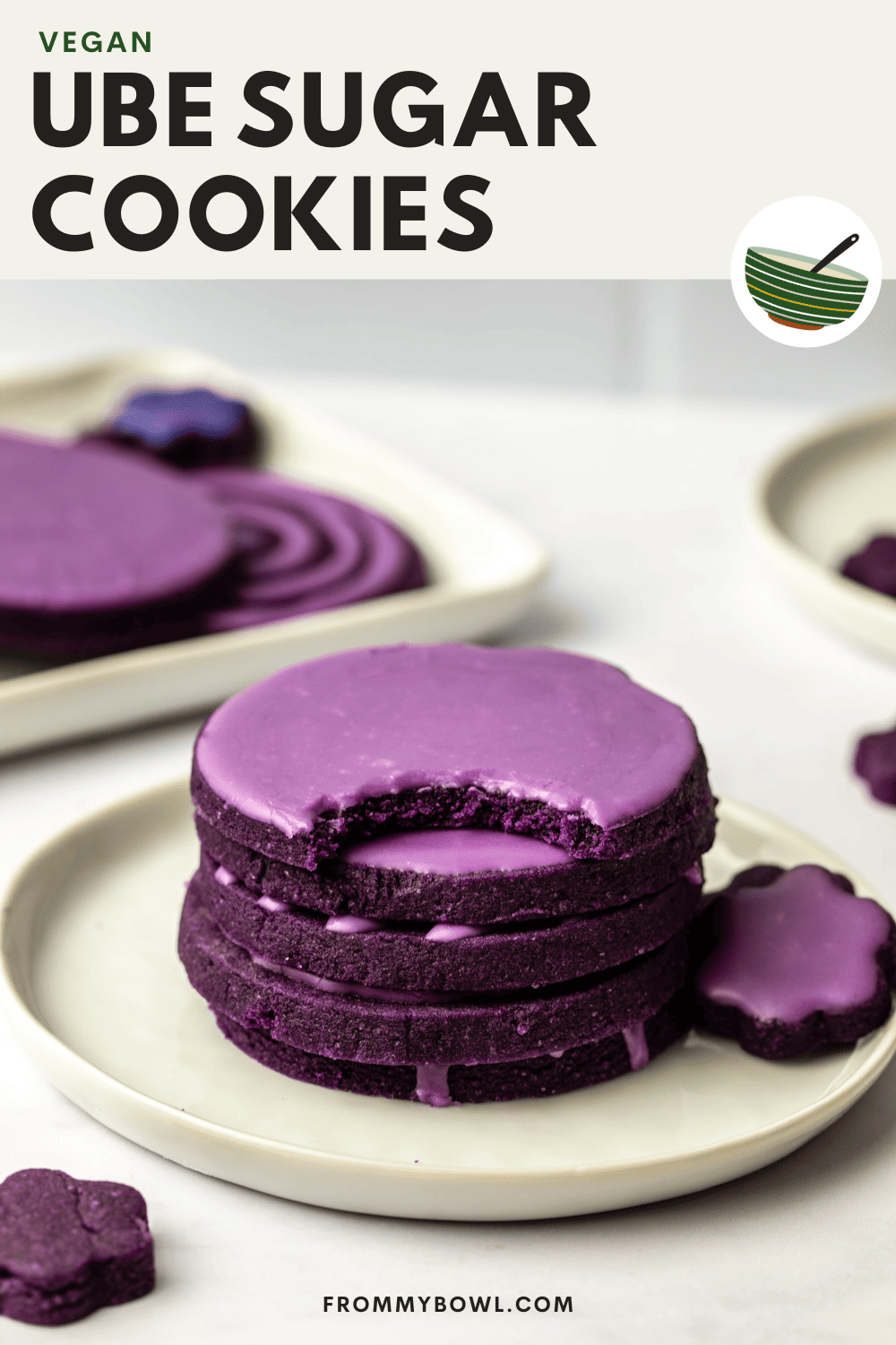glazed ube sugar cookies stacked on top of each other and served in a white plate