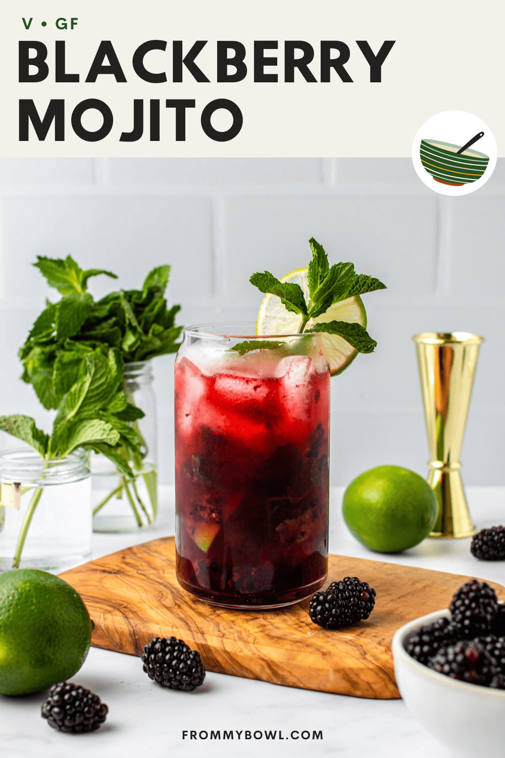 blackberry mojito served in a glass cup on a wooden board with berries, lime and fresh mint in glass jars as decoration