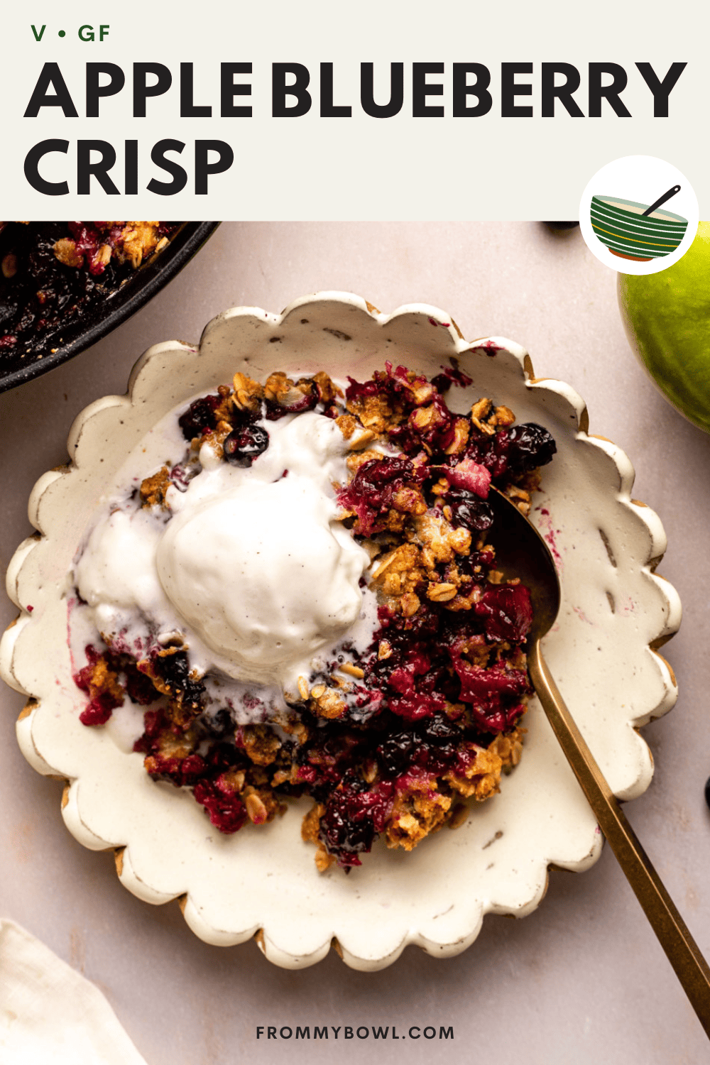 apple blueberry crisp served in a white plate with a scoop of ice cream on top and a spoon ready to dig in