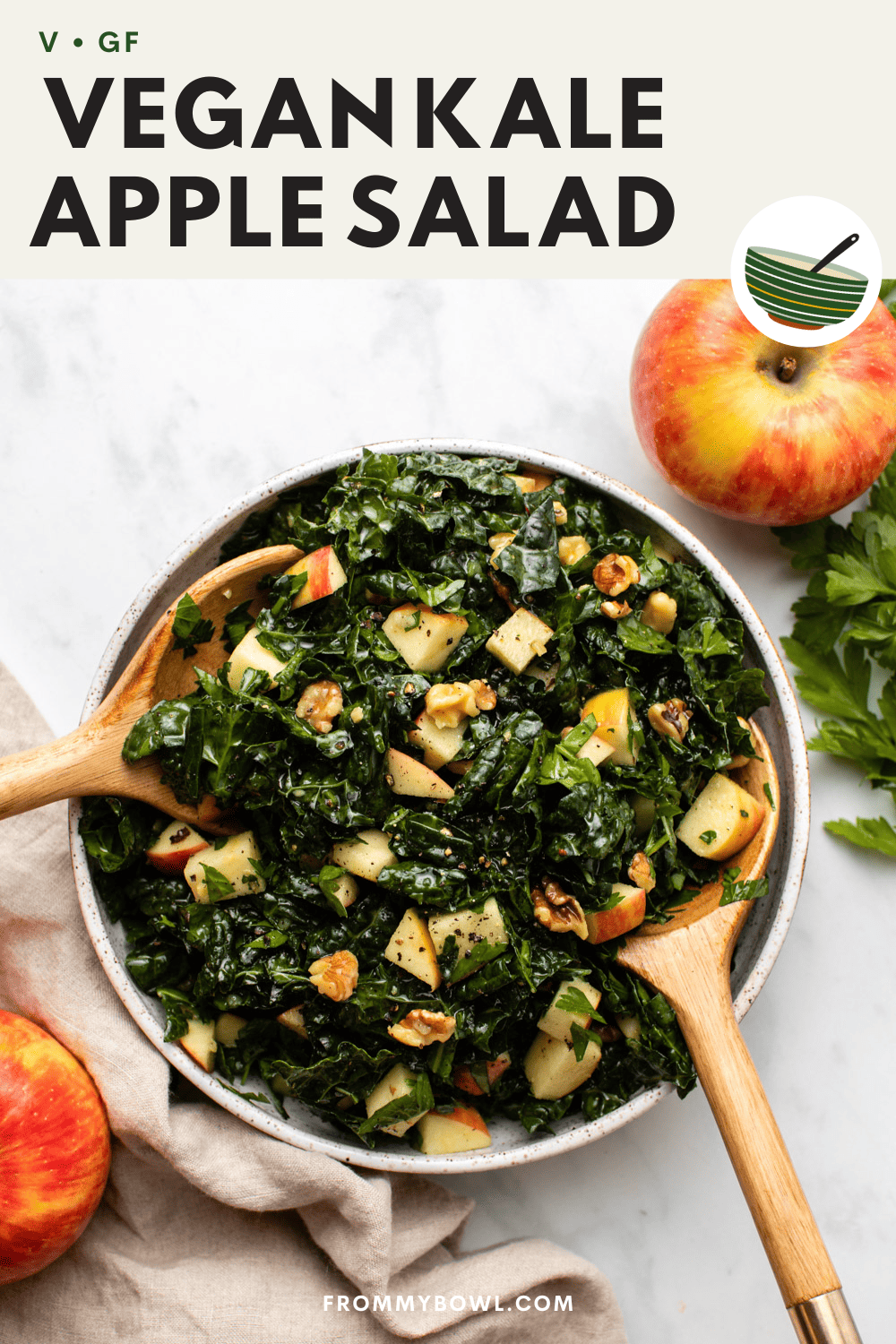 kale apple walnut salad in serving bowl with wooden salad spoons