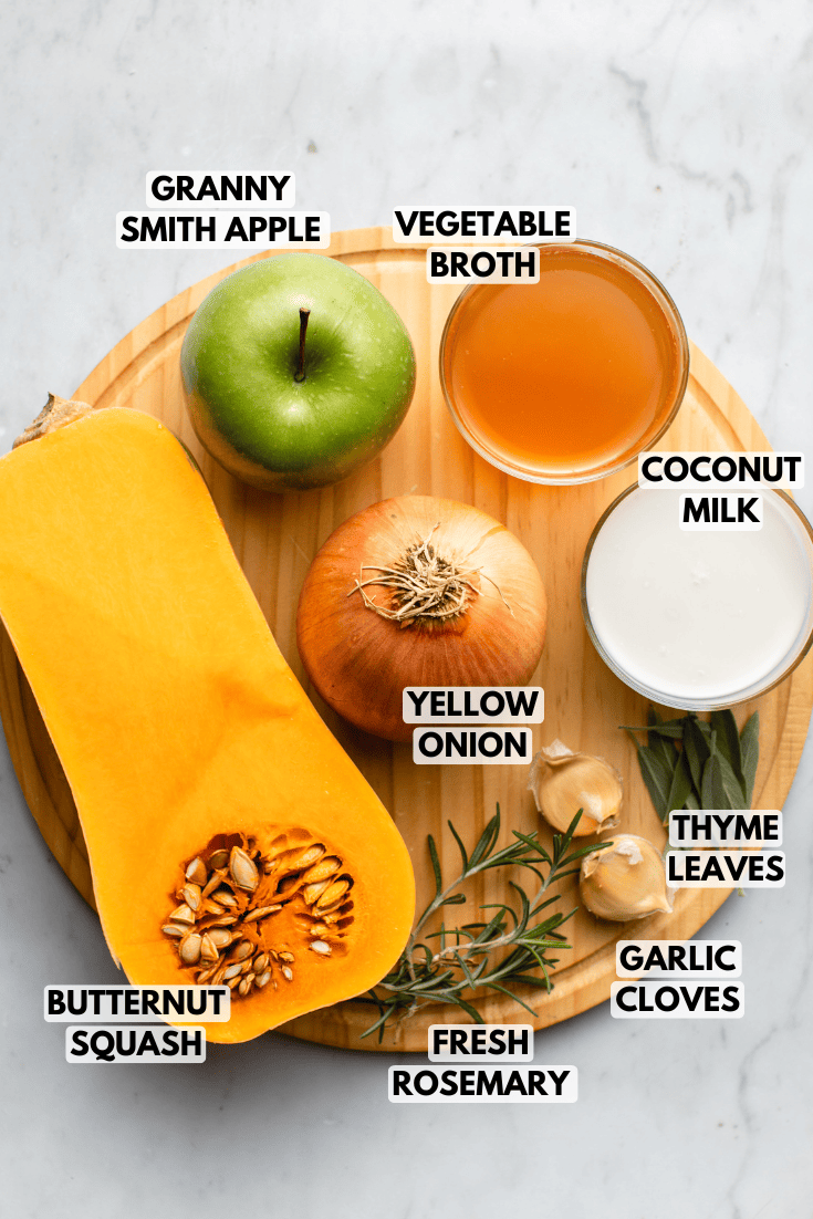 ingredients for butternut squash and apple soup arranged on round wood cutting board