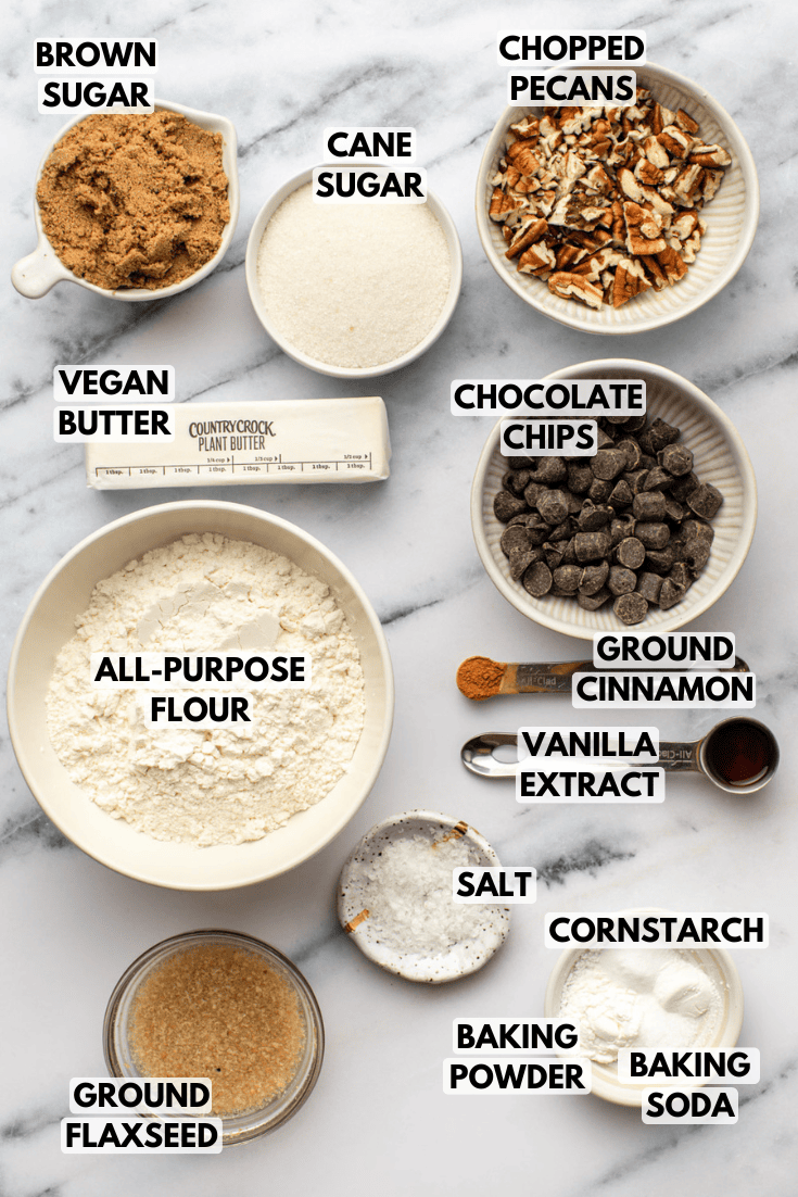 ingredients for chocolate chip pecan cookies laid out on a marble kitchen countertop