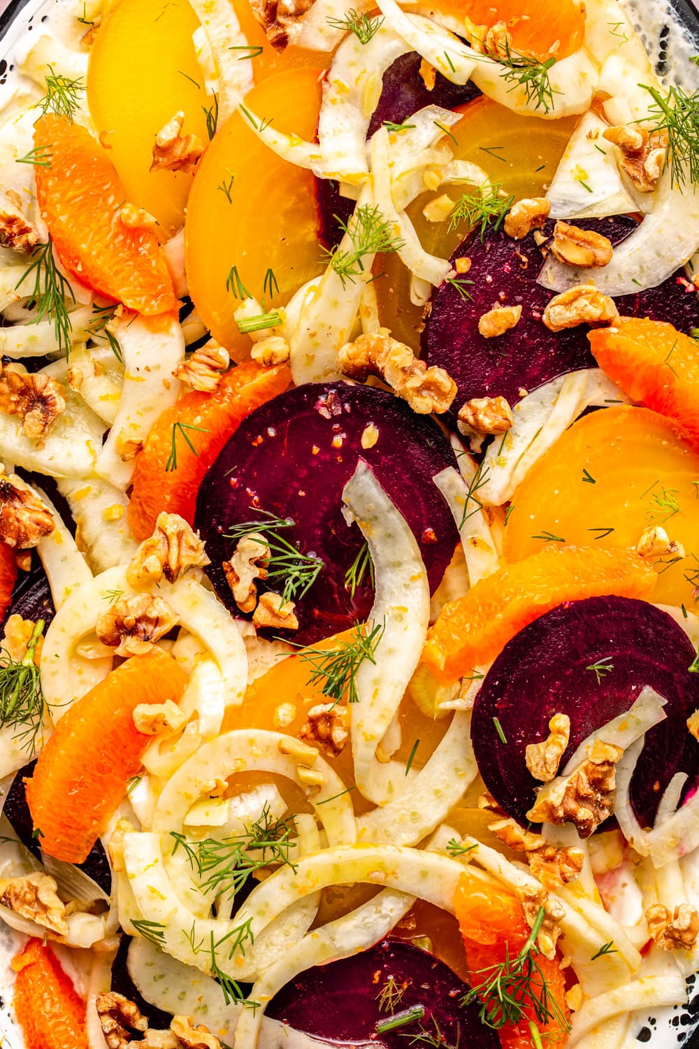 a zoomed in image of the roasted beet and fennel salad topped with fresh dill and walnuts