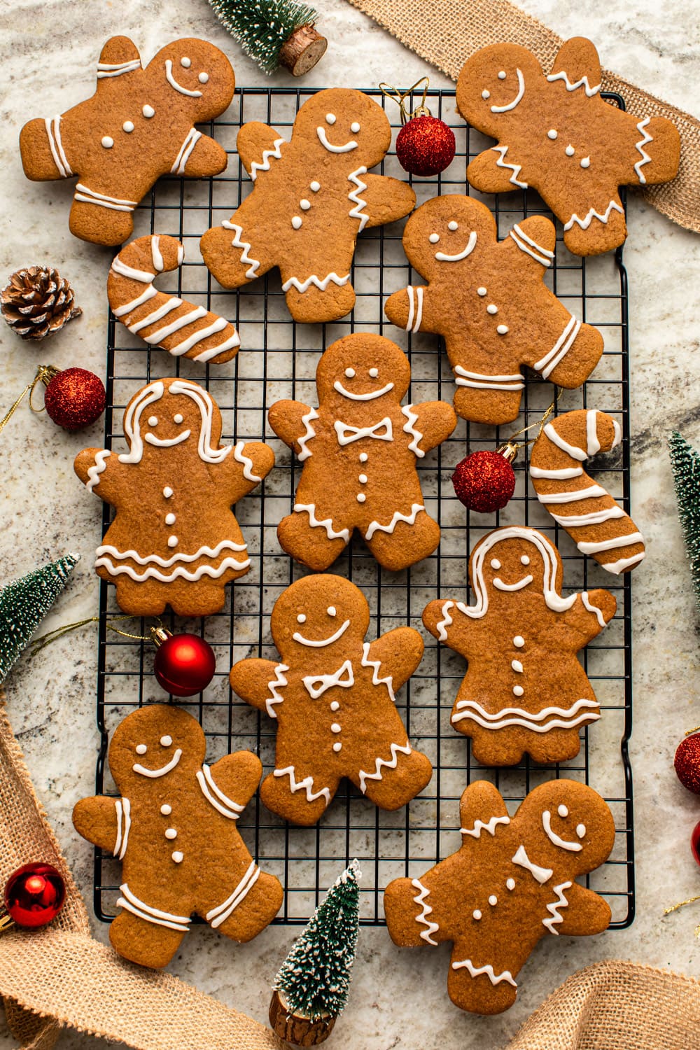 gingerbread cookies laid out on a cooling rack with christmas decorations spread around
