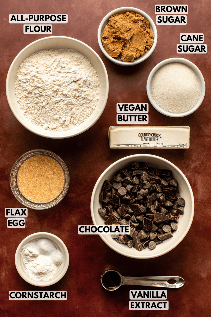 ingredients for the chocolate chip cookie laid out on a dark brown background