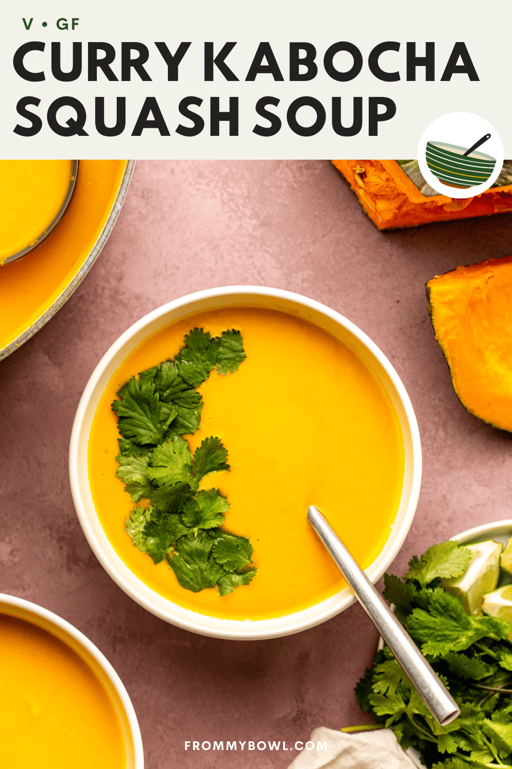 curry kabocha squash soup served in a white bowl and topped with fresh cilantro with a spoon dug in the bowl