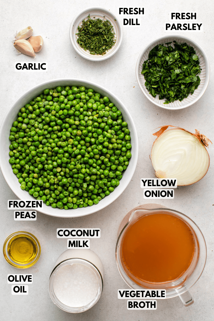 ingredients for green pea soup in various sizes of bowls laid out on a marble kitchen countertop