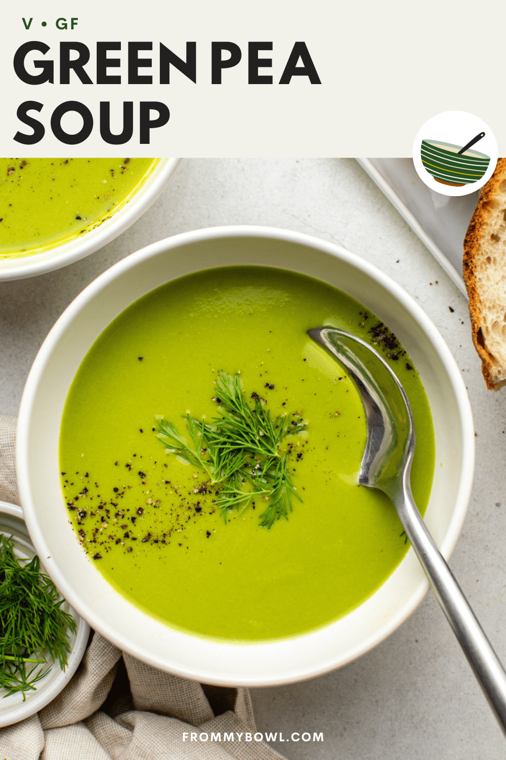 green pea soup served in a white bowl and topped with fresh dill and black pepper with a spoon dug in
