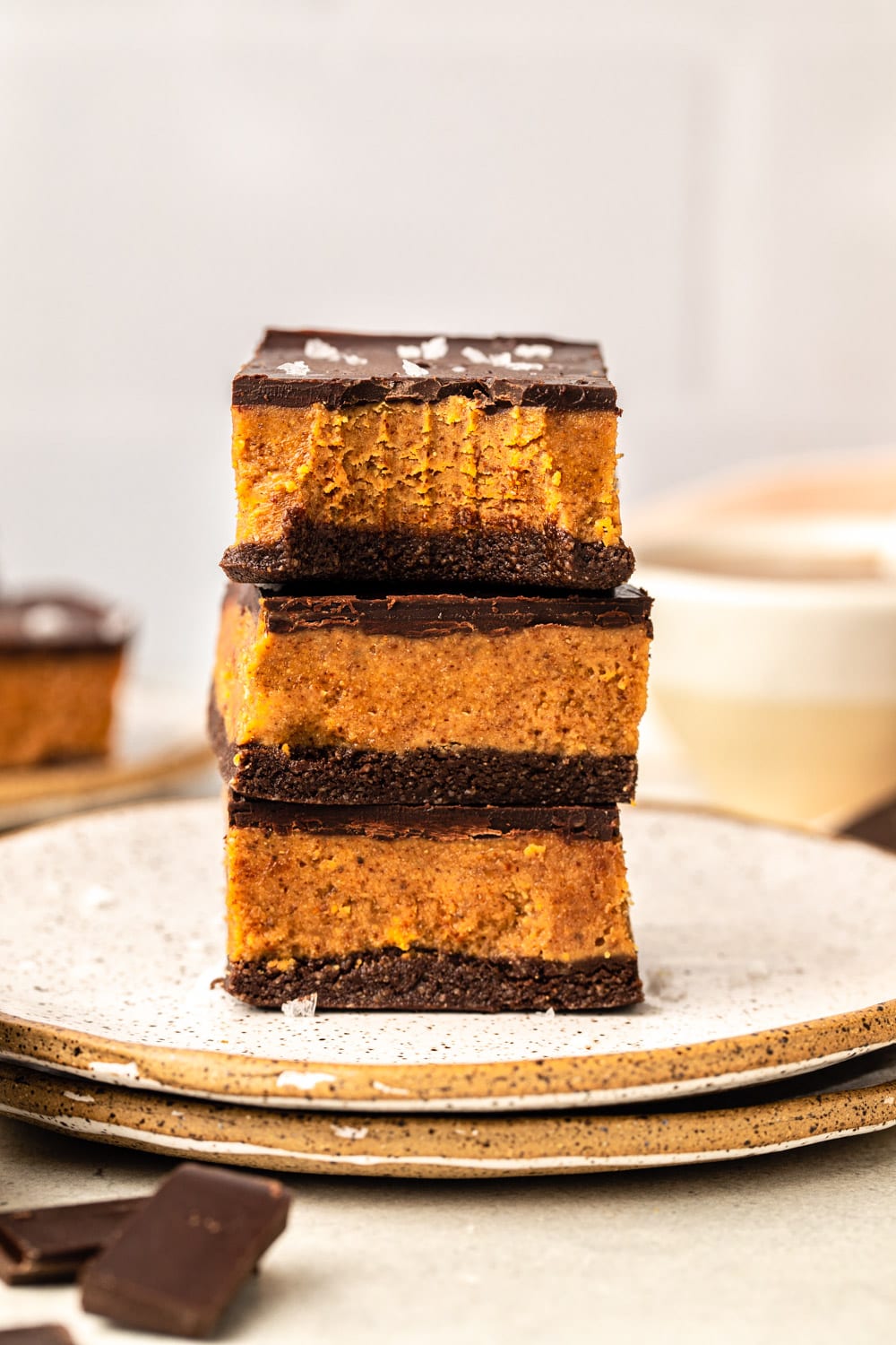 three almond butter bars stacked on top of plates 