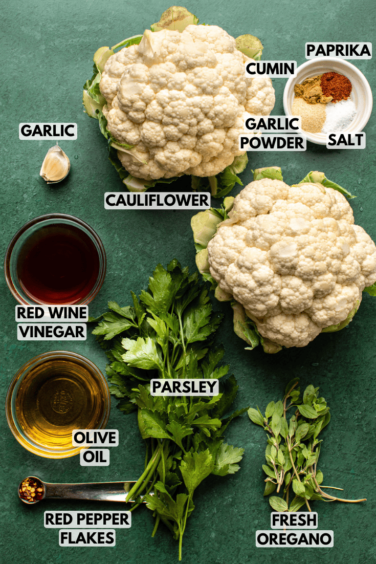 ingredients for cauliflower chimichurri laid out on a dark green countertop