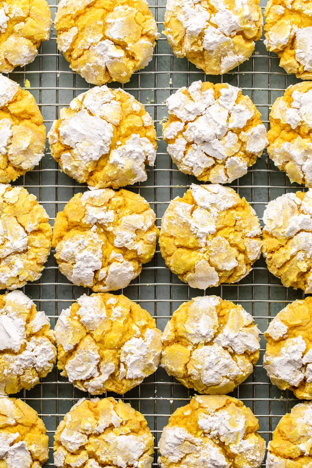 twenty lemon cookies cooling on a cooling rack