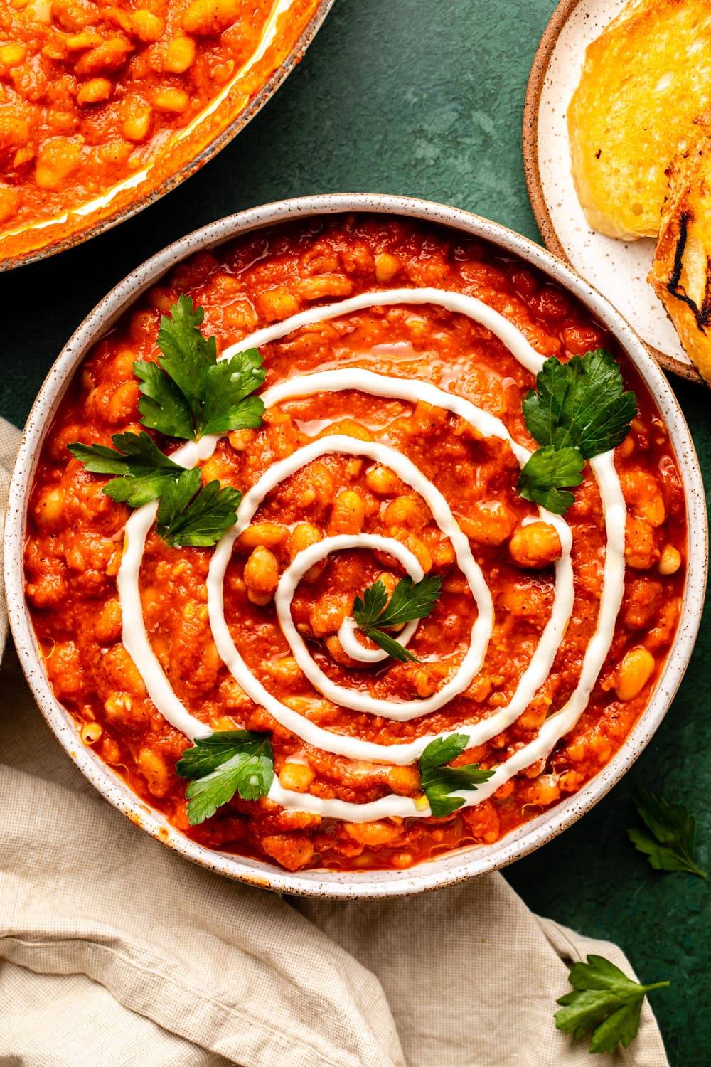 sweet and smoky white beans served in a wide plate topped with cashew cream, parsley