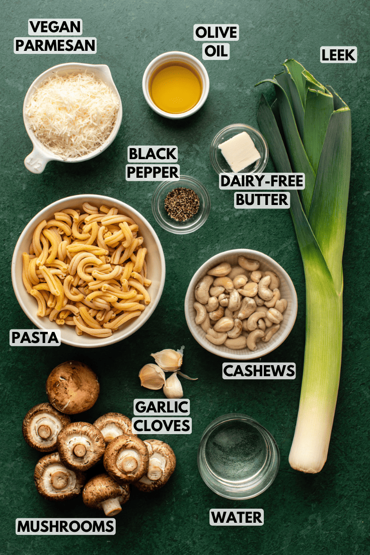 ingredients for mushroom leek pasta laid out on a dark green kitchen countertop