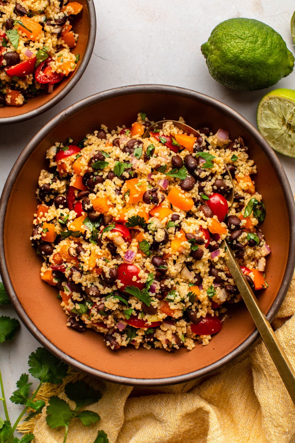 black bean couscous salad served in a wide bowl with a spoon dug in