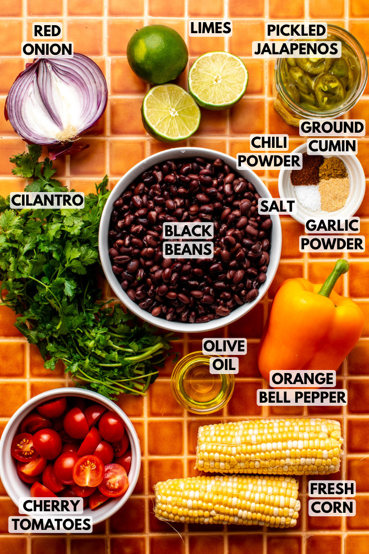 ingredients for tex mex black bean salad laid out on an orange checkered kitchen counter