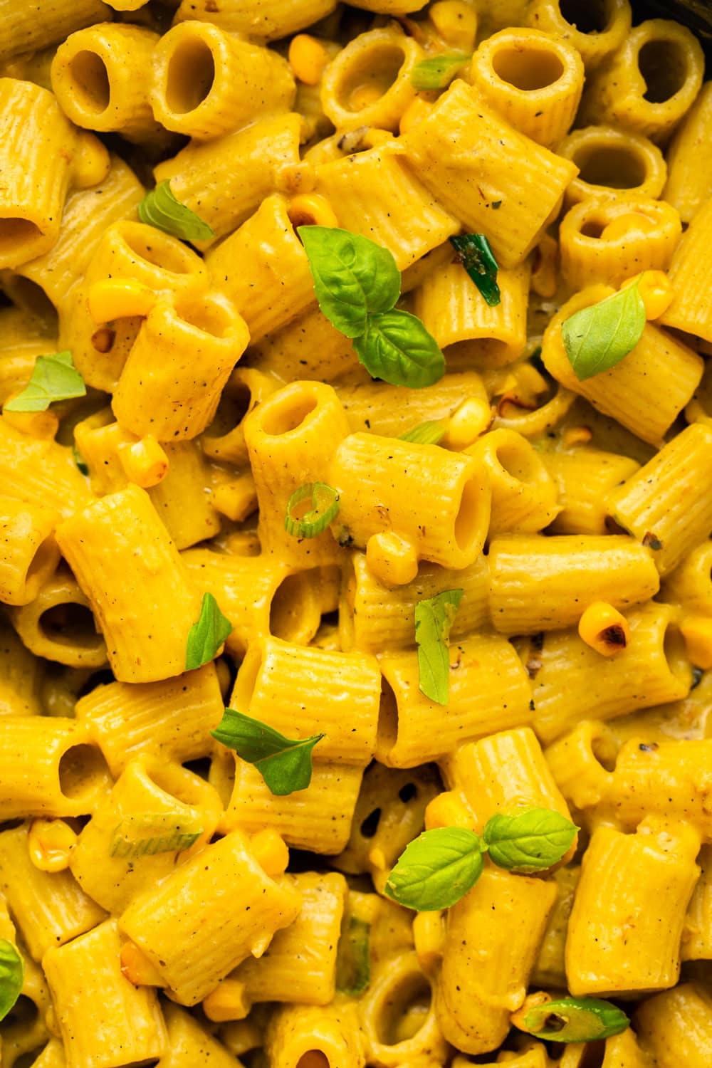 a zoomed in photo of seared corn and basil pasta showing its texture