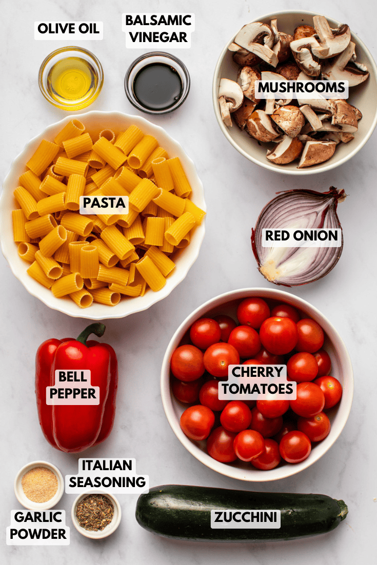 all the ingredients for the roasted vegetable pasta are arranged in small bowls on the kitchen counter, presented in a mise en place style.