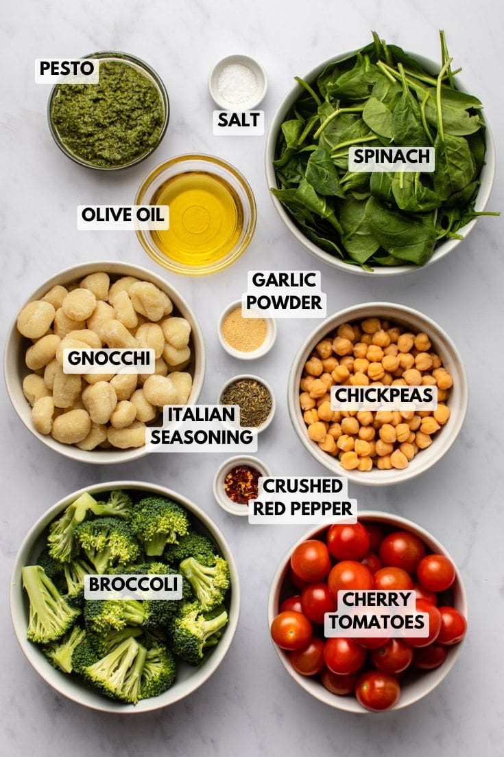 ingredients for sheet pan gnocchi arranged in small bowls on a kitchen countertop, neatly prepared and ready for cooking.