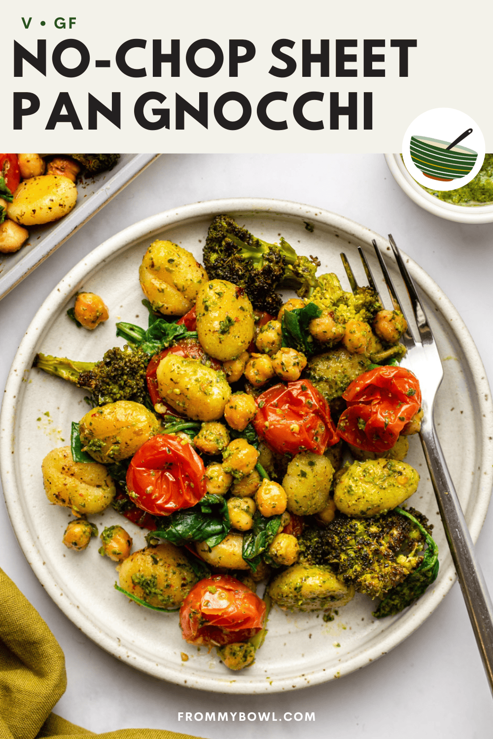 plated sheet pan gnocchi served on a white ceramic plate with a fork placed beside it, set on a kitchen countertop, with the baking tray visible in the background.
