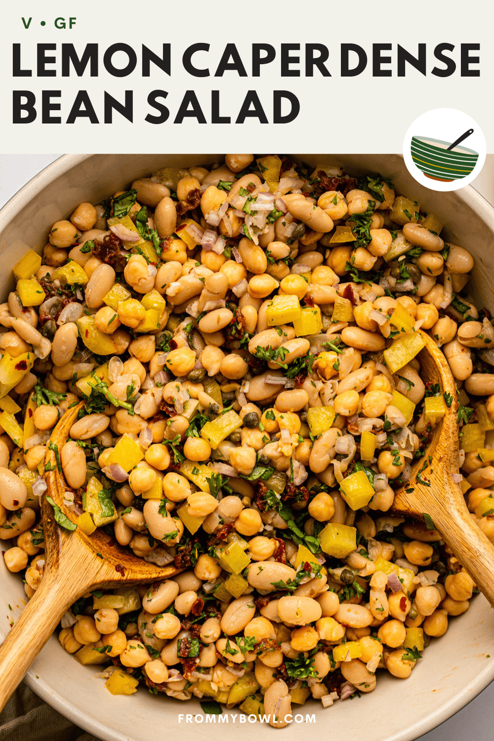 a bowl of lemon caper dense bean salad made with white beans, chickpeas, herbs, and diced yellow bell pepper.
