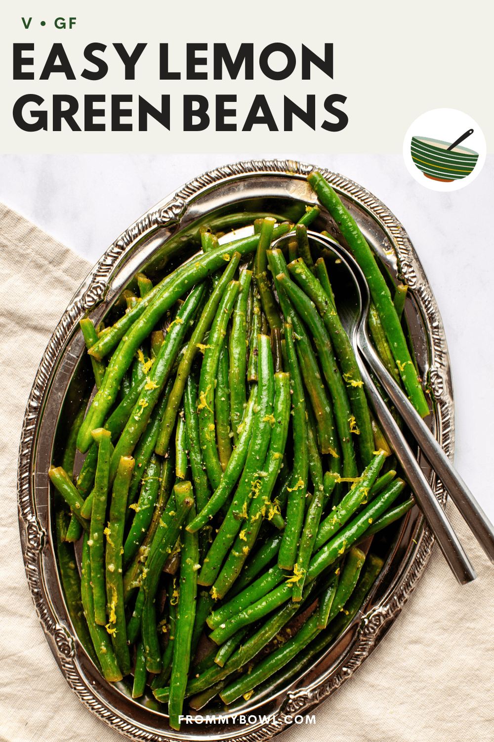 lemon green beans served on a silver platter with garlic and black pepper, topped with fresh lemon zest.