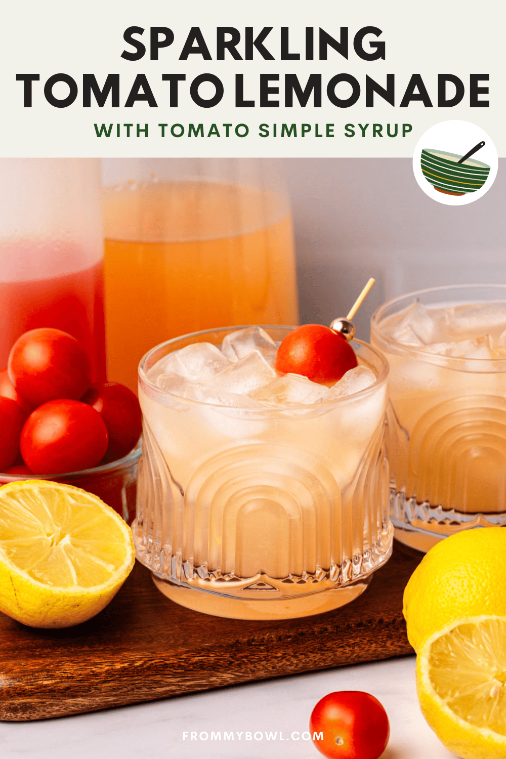 two glasses of sparkling tomato lemonade on a wood cutting board, with jars of lemonade and tomato simple syrup in the background