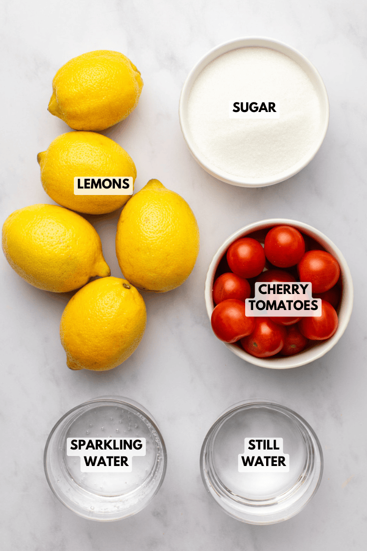 Ingredients for tomato lemonade arranged on a marble countertop